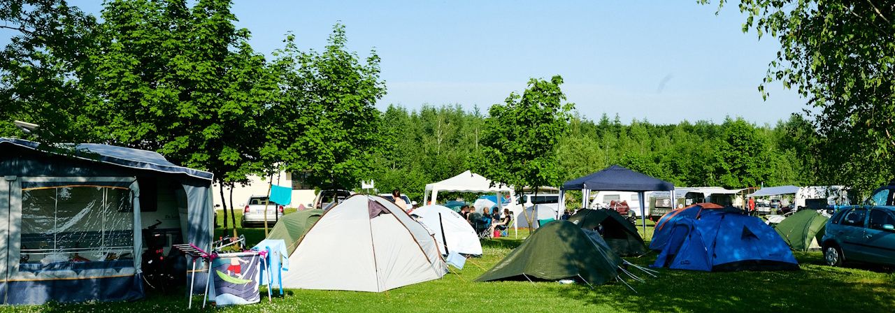 Campingplatz mit mehreren Zelten an einem sonnigen Tag