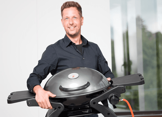 Mann hält Gasgrill in der Hand